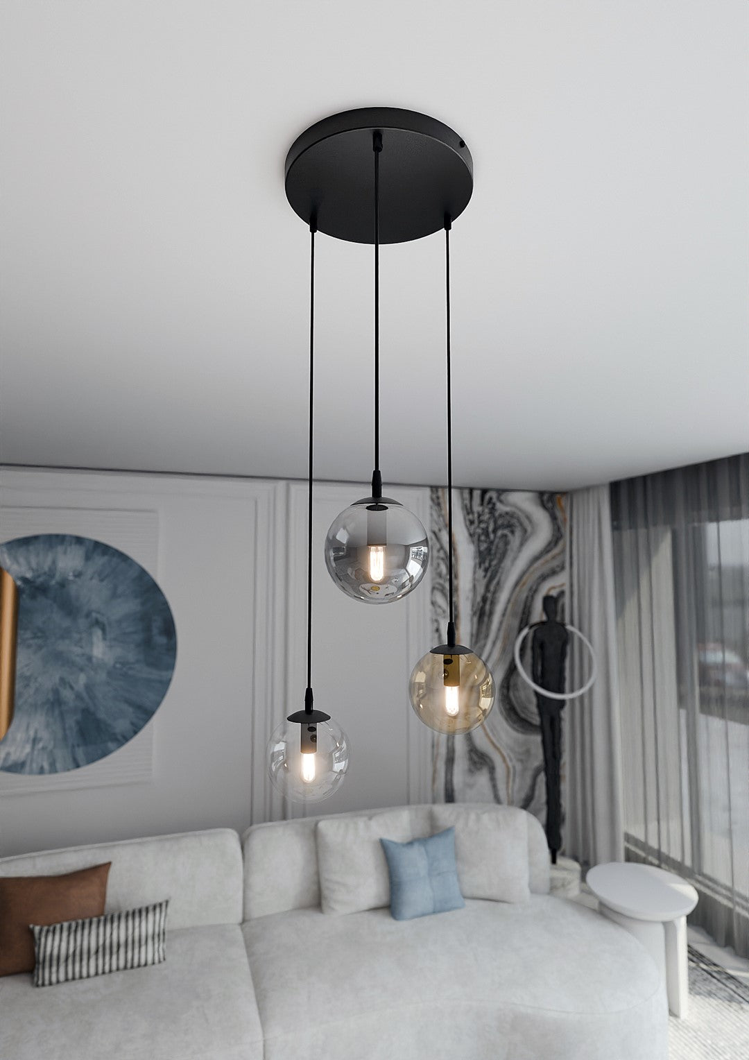 Suspension noire allumée dans un salon clair, trois globes suspendus devant un mur décoratif