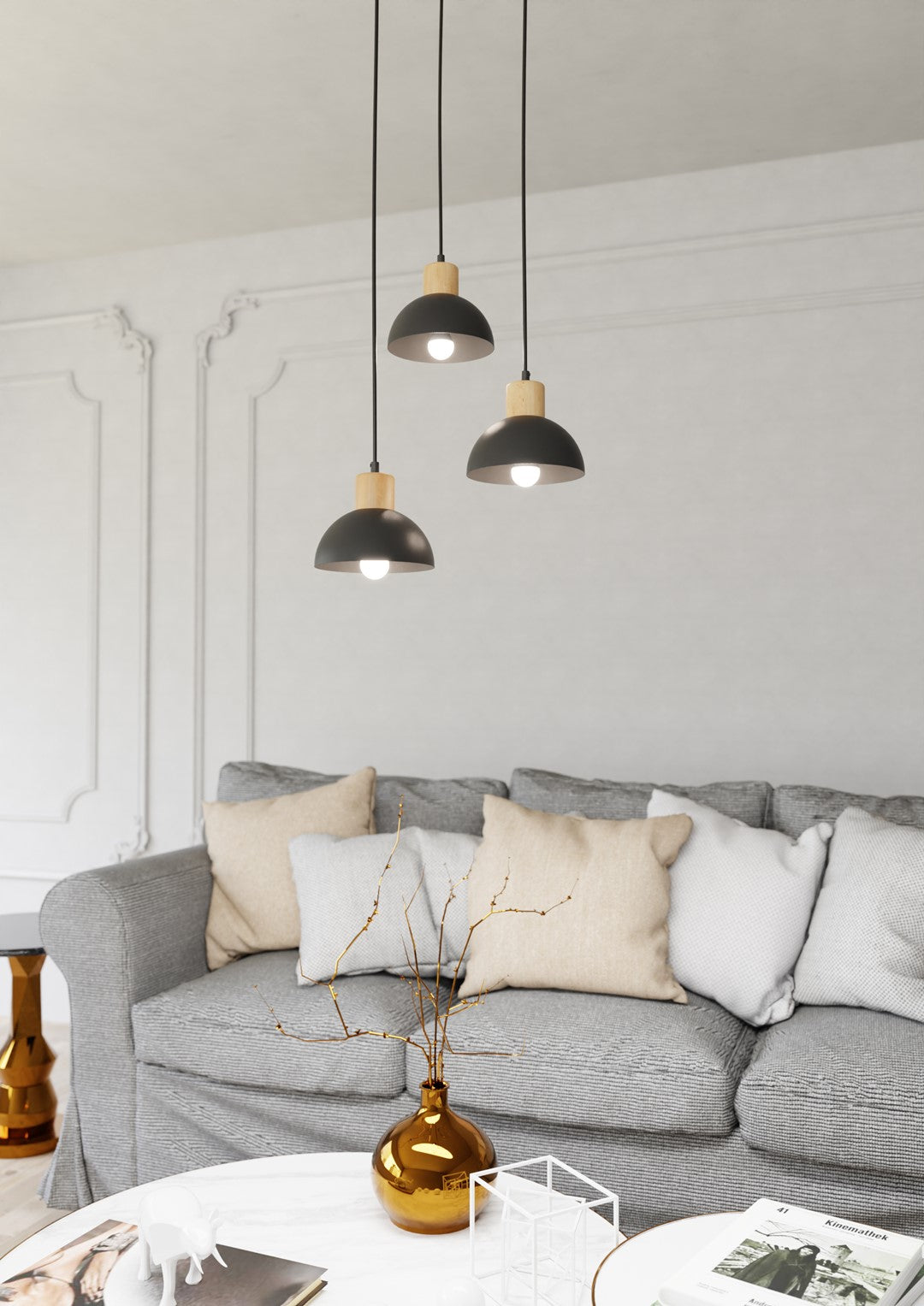 Suspension éclairée au-dessus d'un canapé gris dans un salon aux moulures blanches
