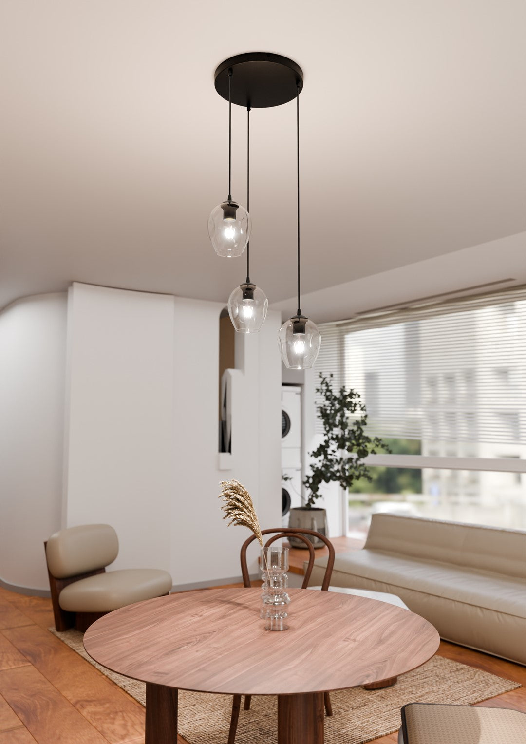 Suspension noire trois lumières allumées au-dessus d'une table en bois près d'une fenêtre.