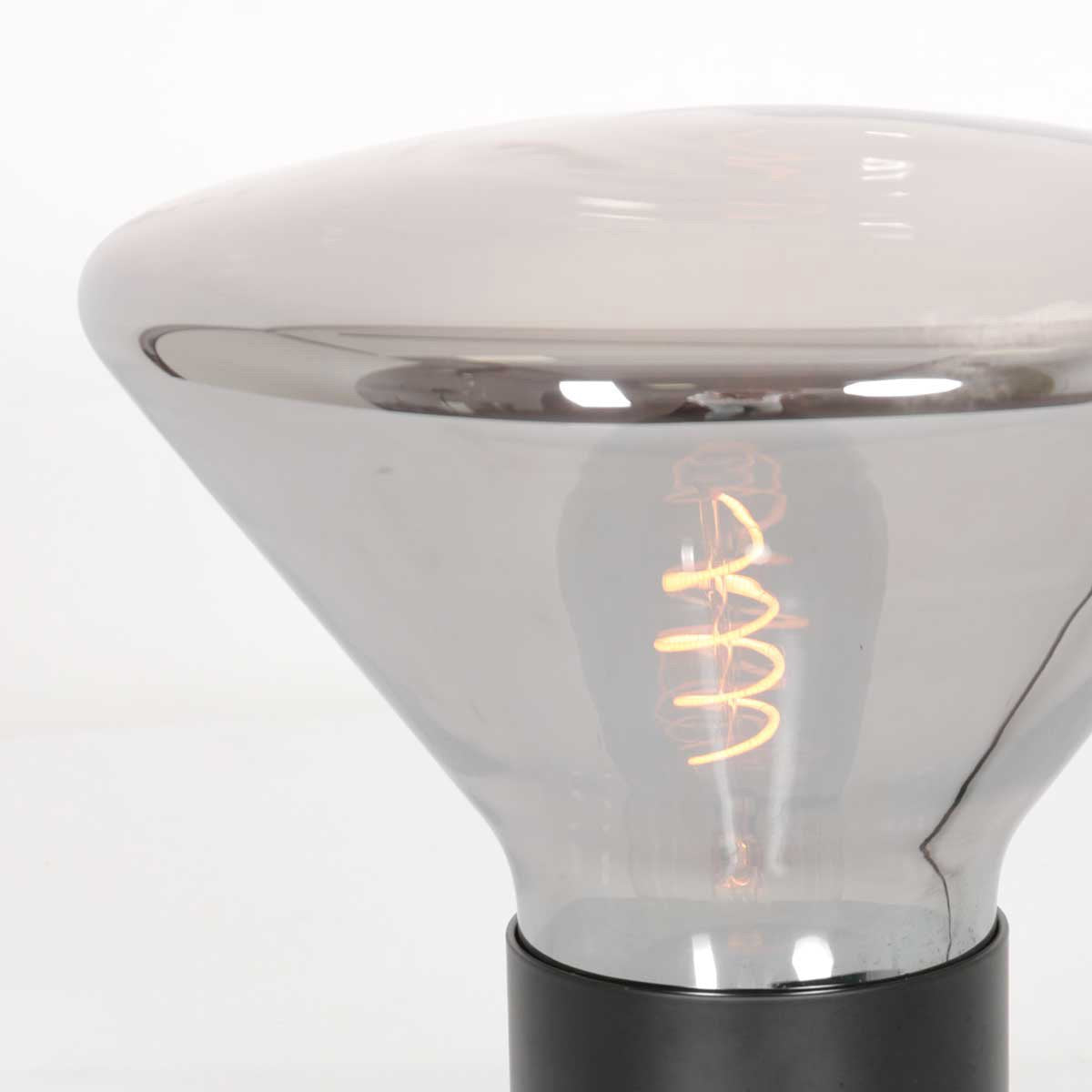Gros plan sur la surface du verre fumé et le reflet de l'ampoule dorée