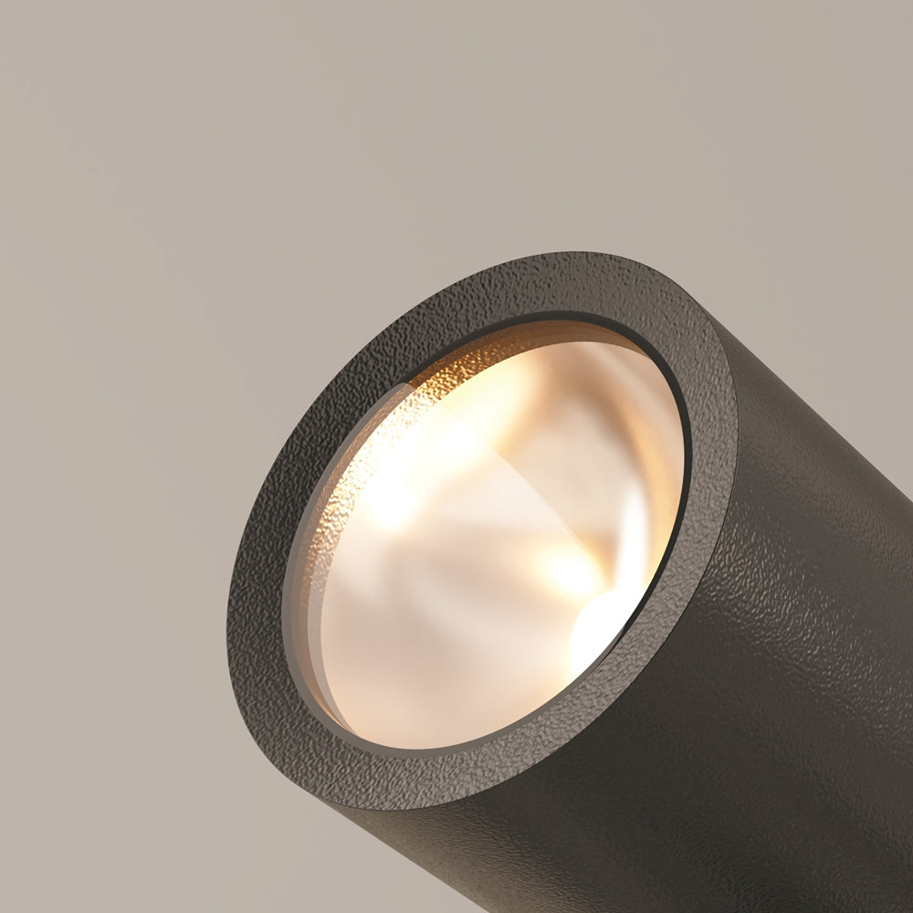 Détail du verre et de la lentille diffusant une lumière chaude sur fond beige
