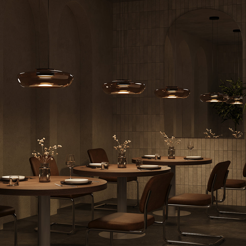 Mise en ambiance dans un restaurant sombre, plusieurs suspensions au dessus des tables