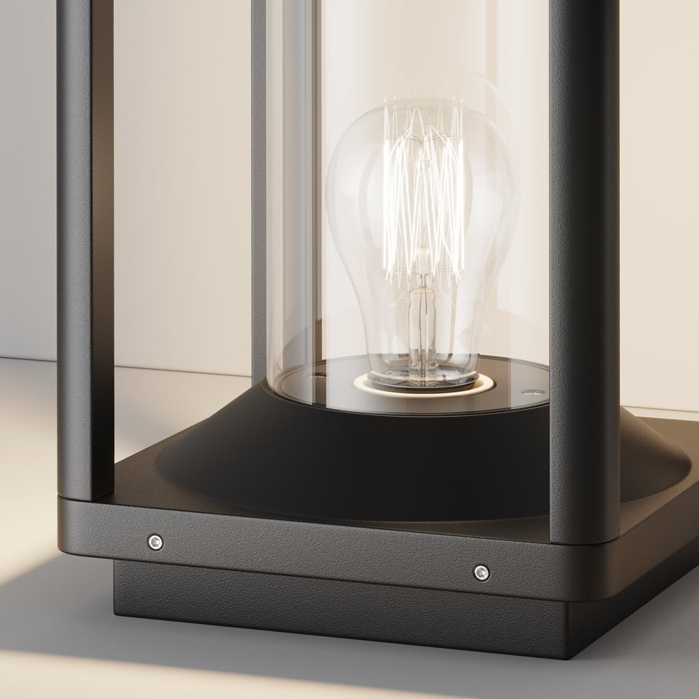 Détail du socle noir mat avec vis apparentes, cylindre de verre et ampoule filament
