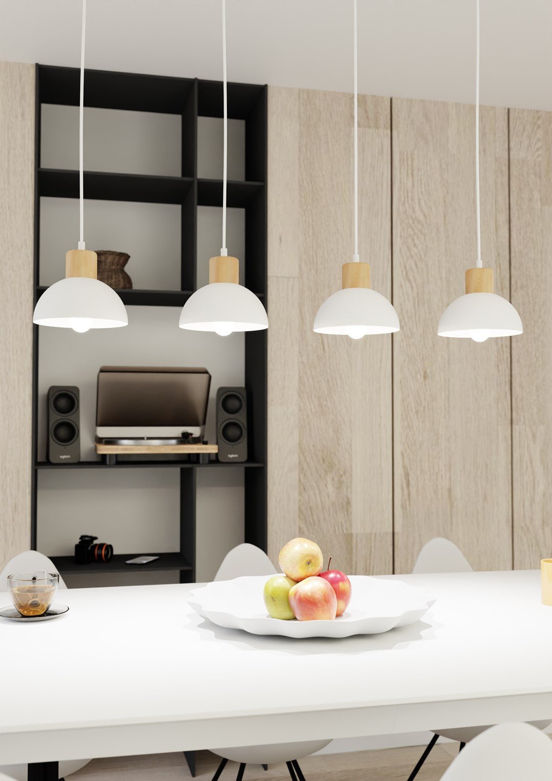 Gros plan sur la suspension et la table dressée avec corbeille de fruits et meuble noir.