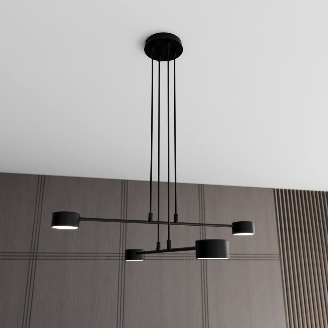 Suspension noire à quatre lumières installée devant un mur lambrissé.