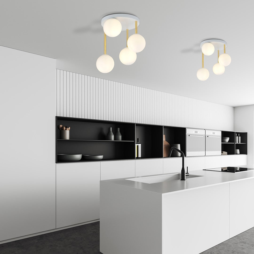 Deux plafonniers installés dans une cuisine blanche moderne au-dessus de l'îlot central