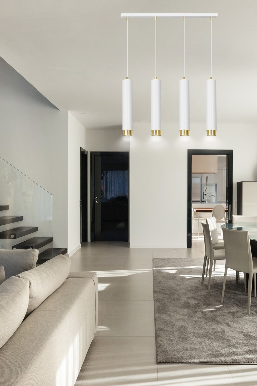 Suspension installée dans un séjour moderne, au-dessus d'une table à manger blanche.