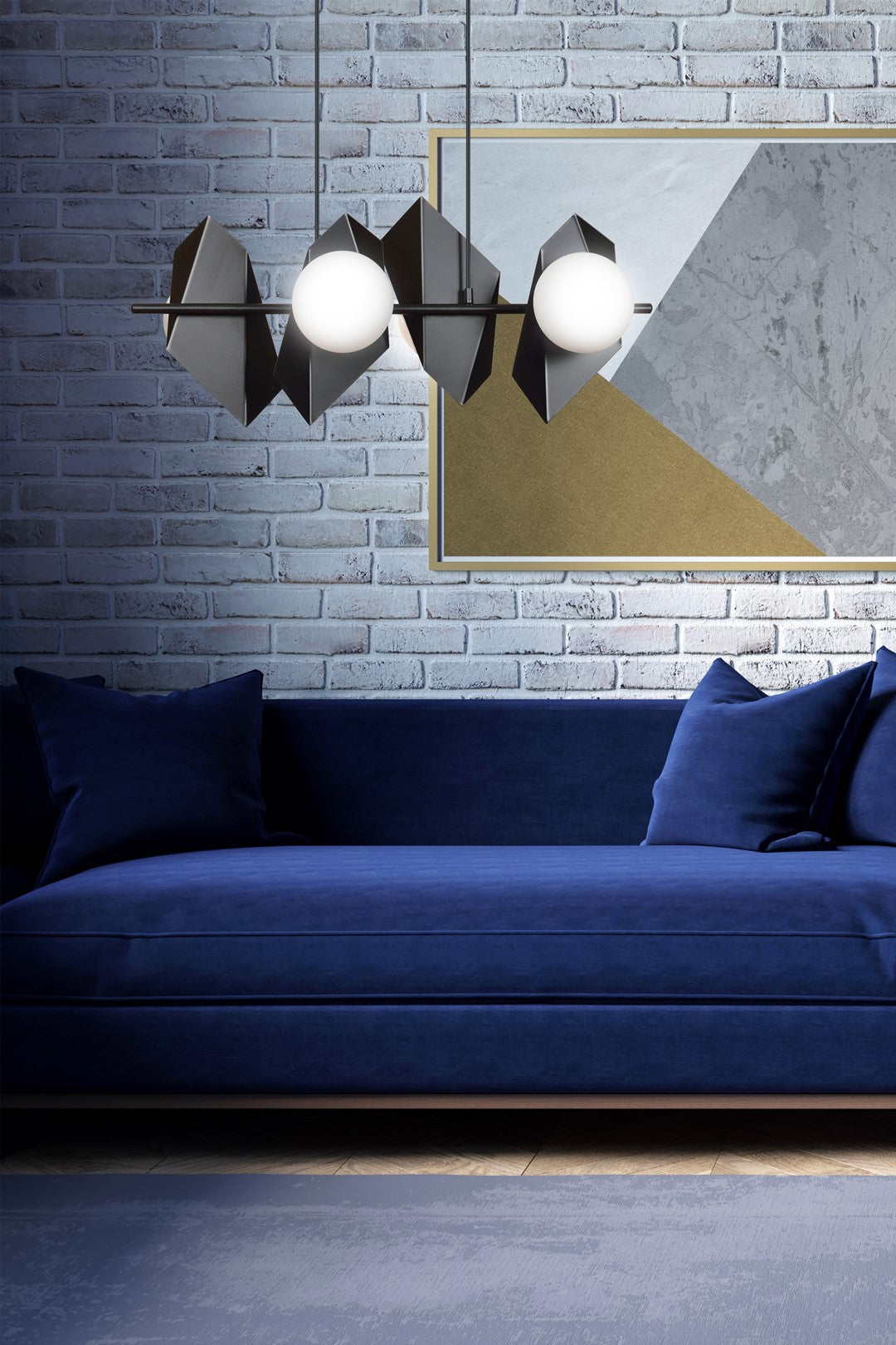 Mise en ambiance salon avec suspension noire, mur brique blanc et canapé bleu.