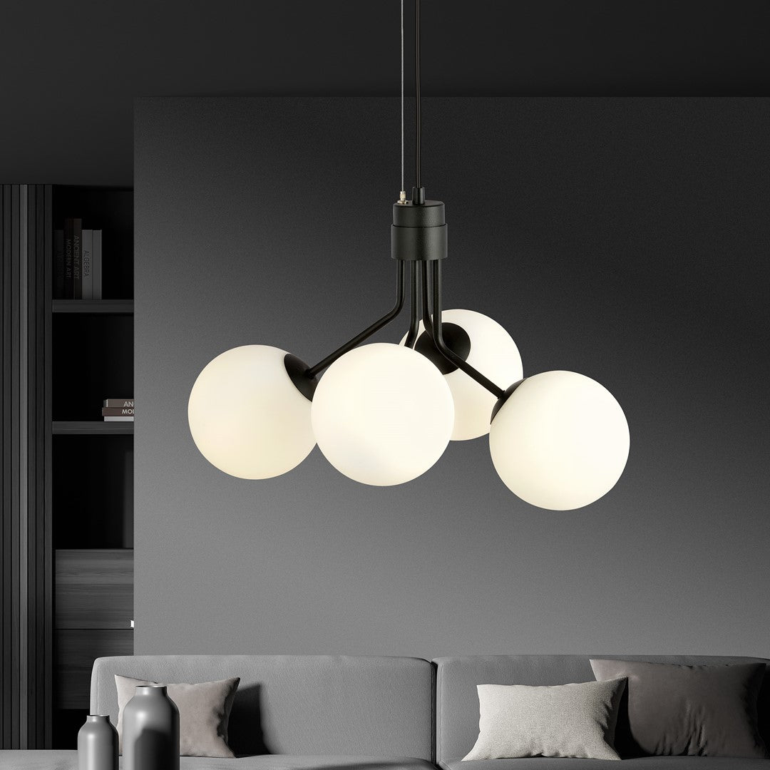 Luminaire suspendu éclairé dans un intérieur sombre avec bibliothèque et canapé gris