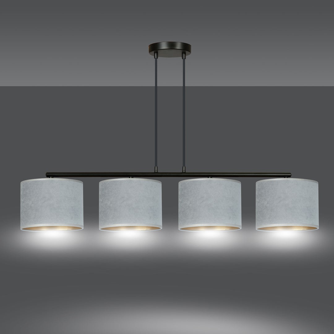 Le luminaire allumé éclaire vers le bas, halos lumineux sous les abat-jours dorés