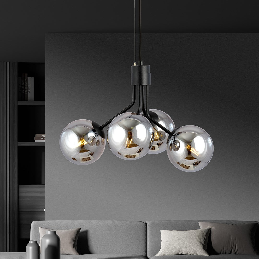Luminaire suspendu au-dessus d'un canapé gris dans un intérieur sombre et épuré.