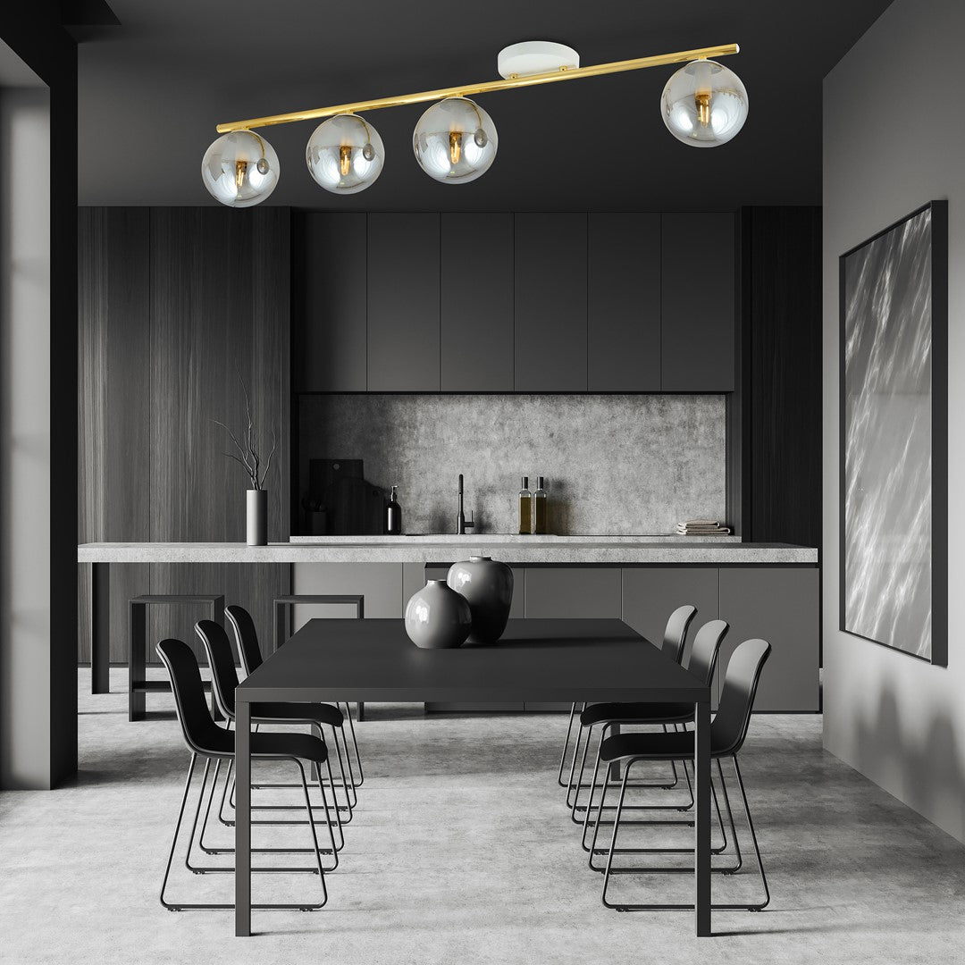 Luminaire doré éclairant une salle à manger sombre avec table et chaises design.
