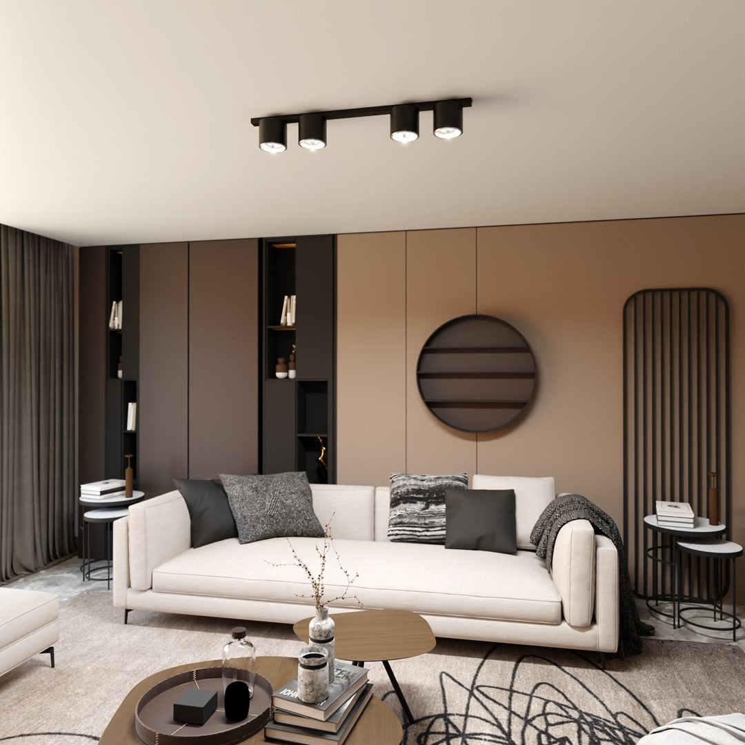 Mise en ambiance dans un salon moderne, plafonnier noir aligné au-dessus du canapé