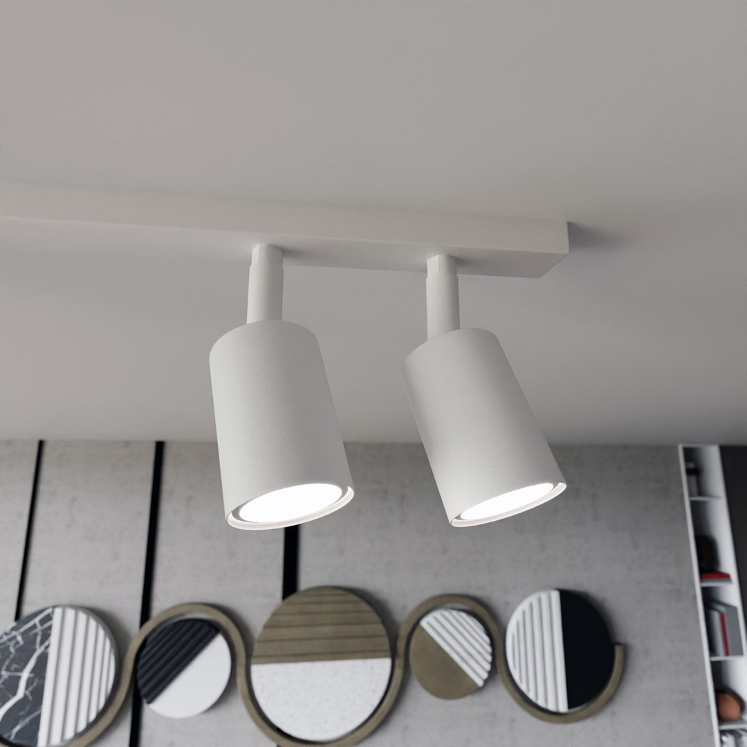 Gros plan sur deux projecteurs cylindriques blancs orientables, finition mate.