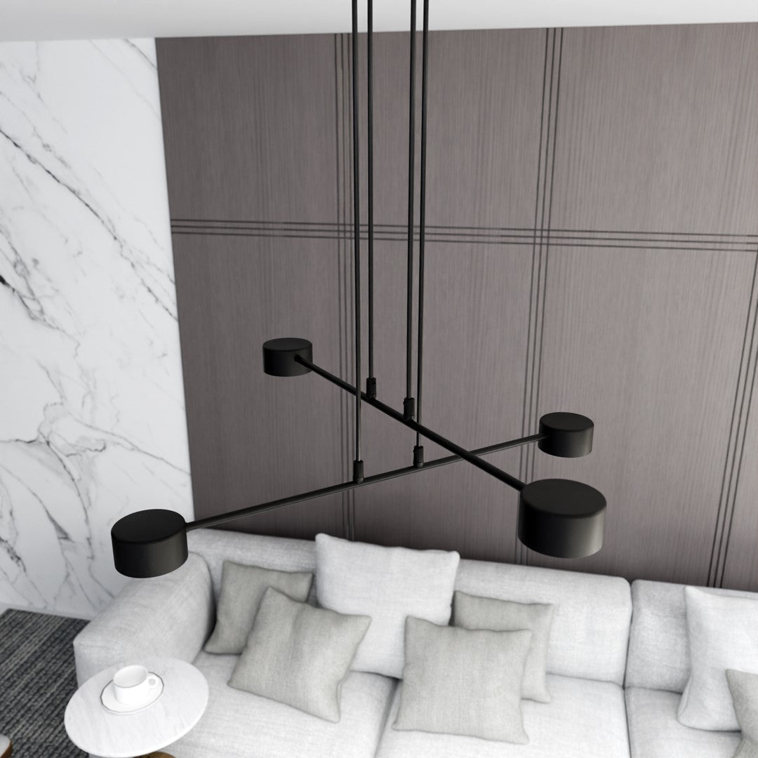 Suspension noire à quatre lumières au-dessus d'un canapé contemporain.