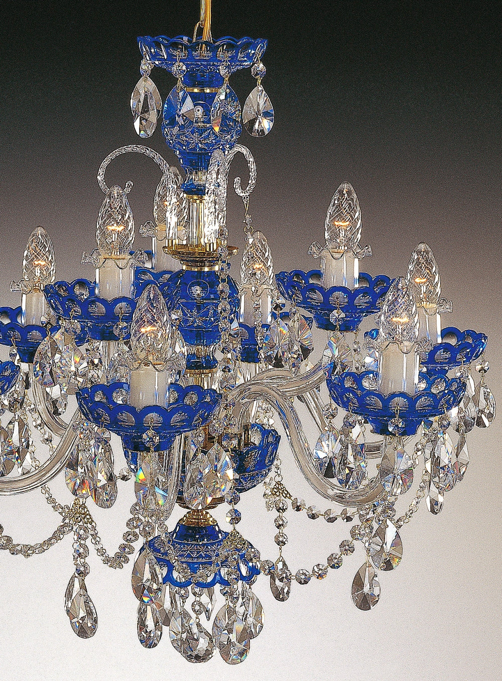 Gros plan sur les bras courbes, coupelles bleues et pendeloques de cristal