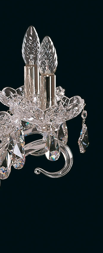 Détail rapproché des bras du lustre, montrant les bobèches en cristal et les gouttes