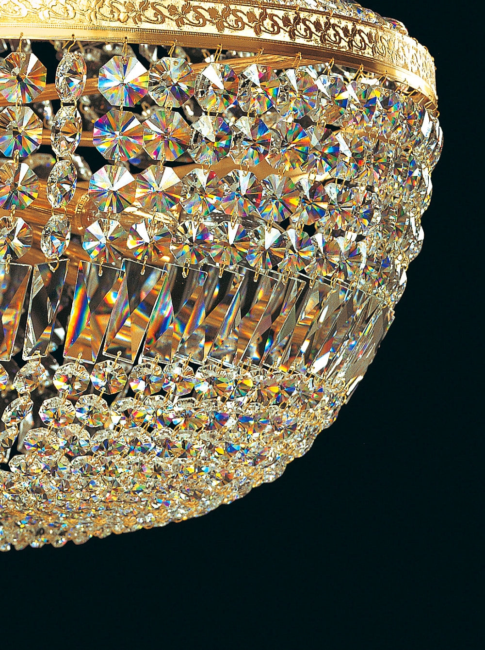 Détail des cristaux taillés et du bandeau doré sur la partie basse du lustre.