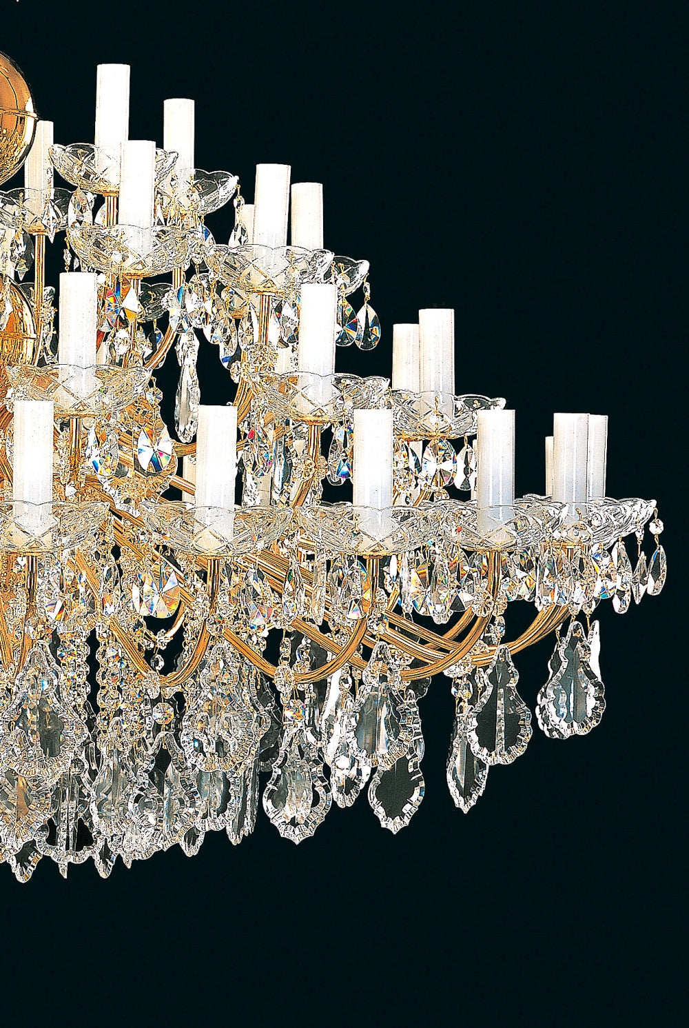 Détail des bras dorés, coupelles et pendants en cristal du luminaire
