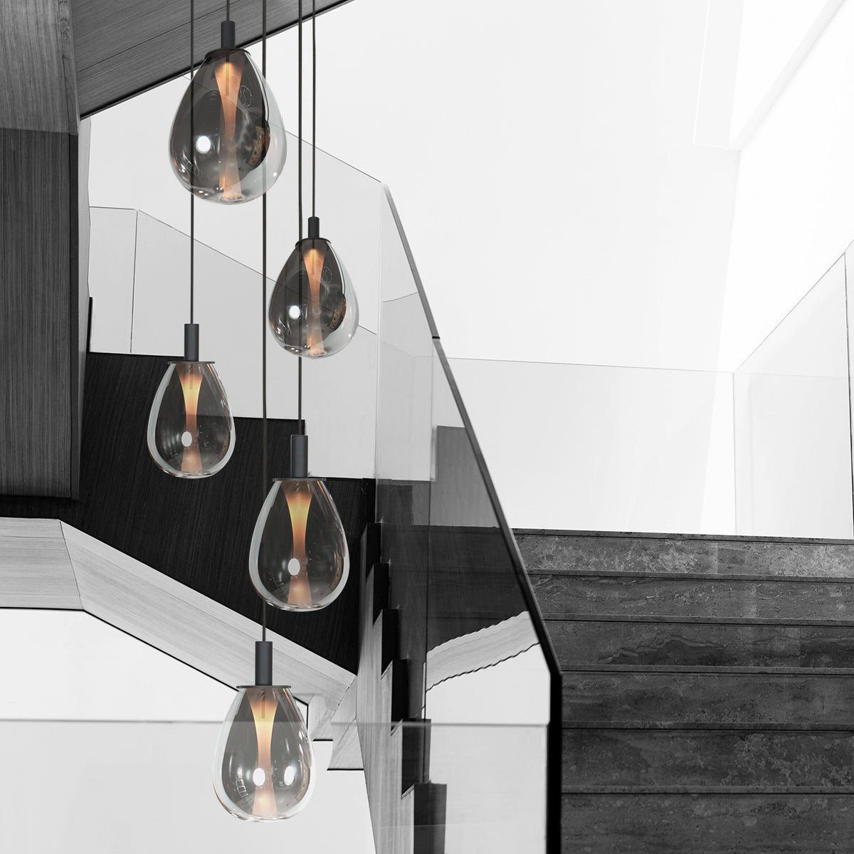 Suspension grappe Glimsy en verre fumé, 5 feux cascade dans une cage d'escalier double hauteur – Designix.fr