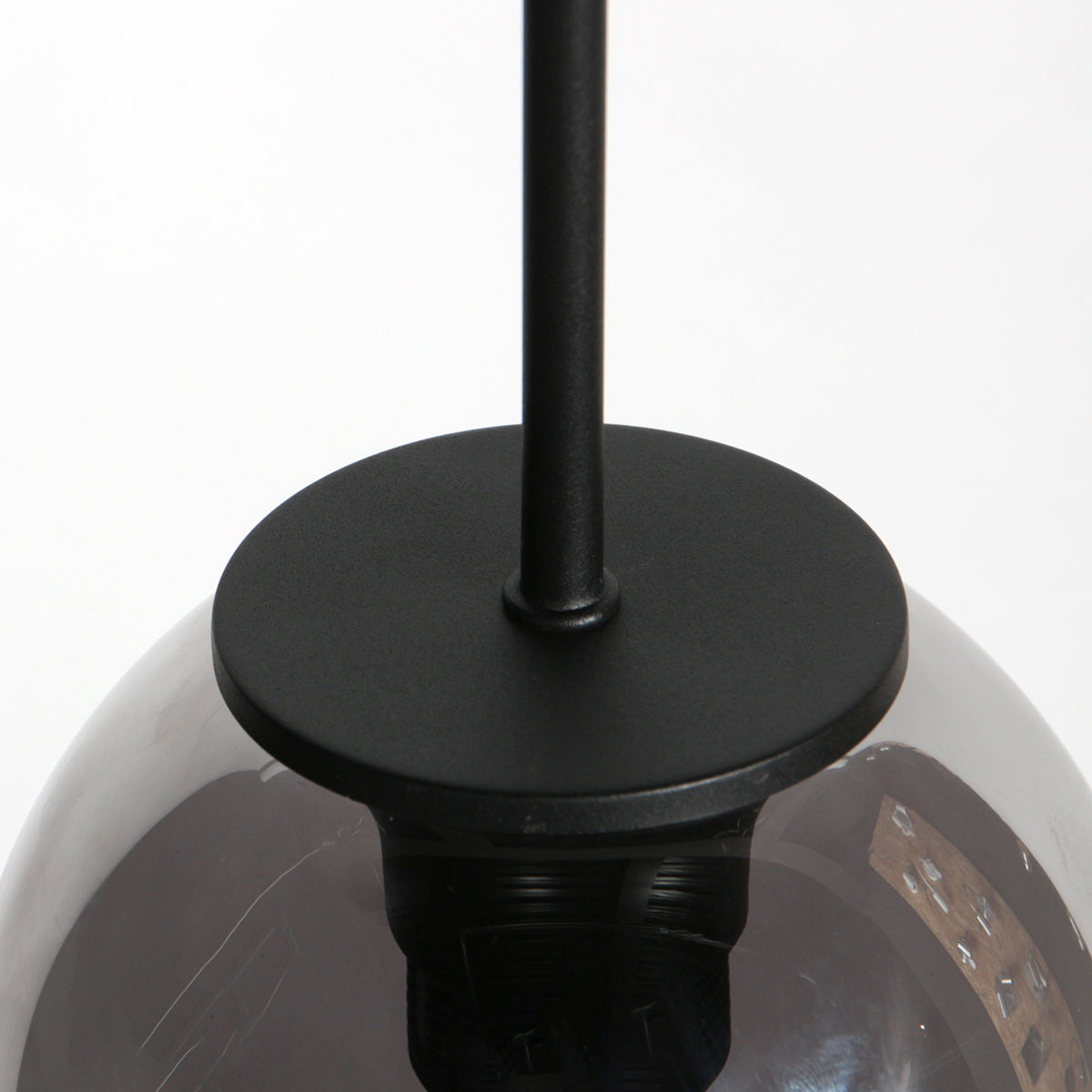 Détail du support métallique noir et de la douille sur le globe en verre