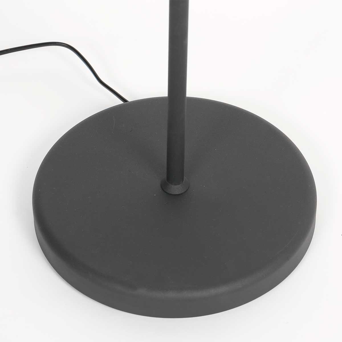 Détail de la base ronde noire du lampadaire et du câble d'alimentation qui sort.