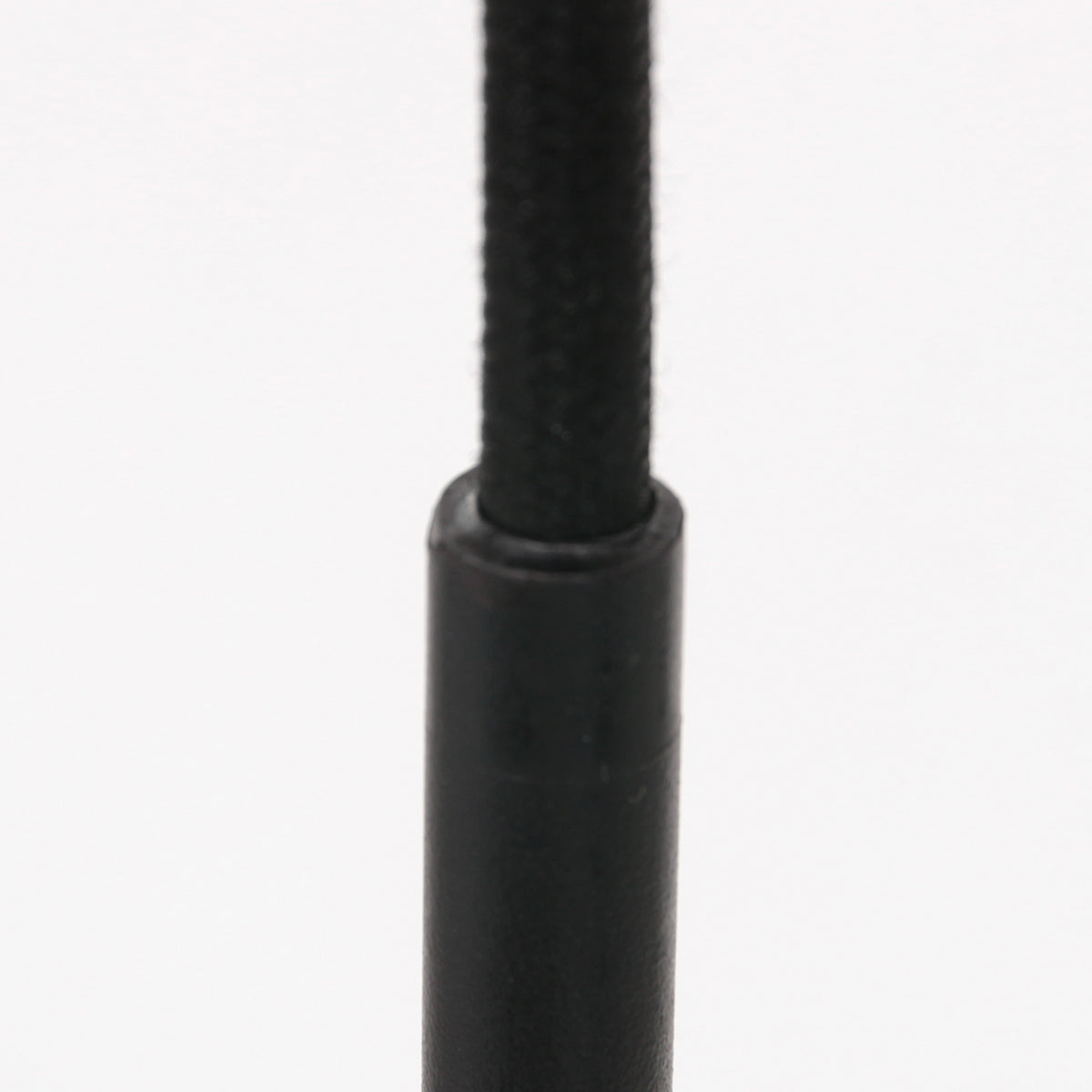 Détail du câble textile noir et de la bague de raccord cylindrique