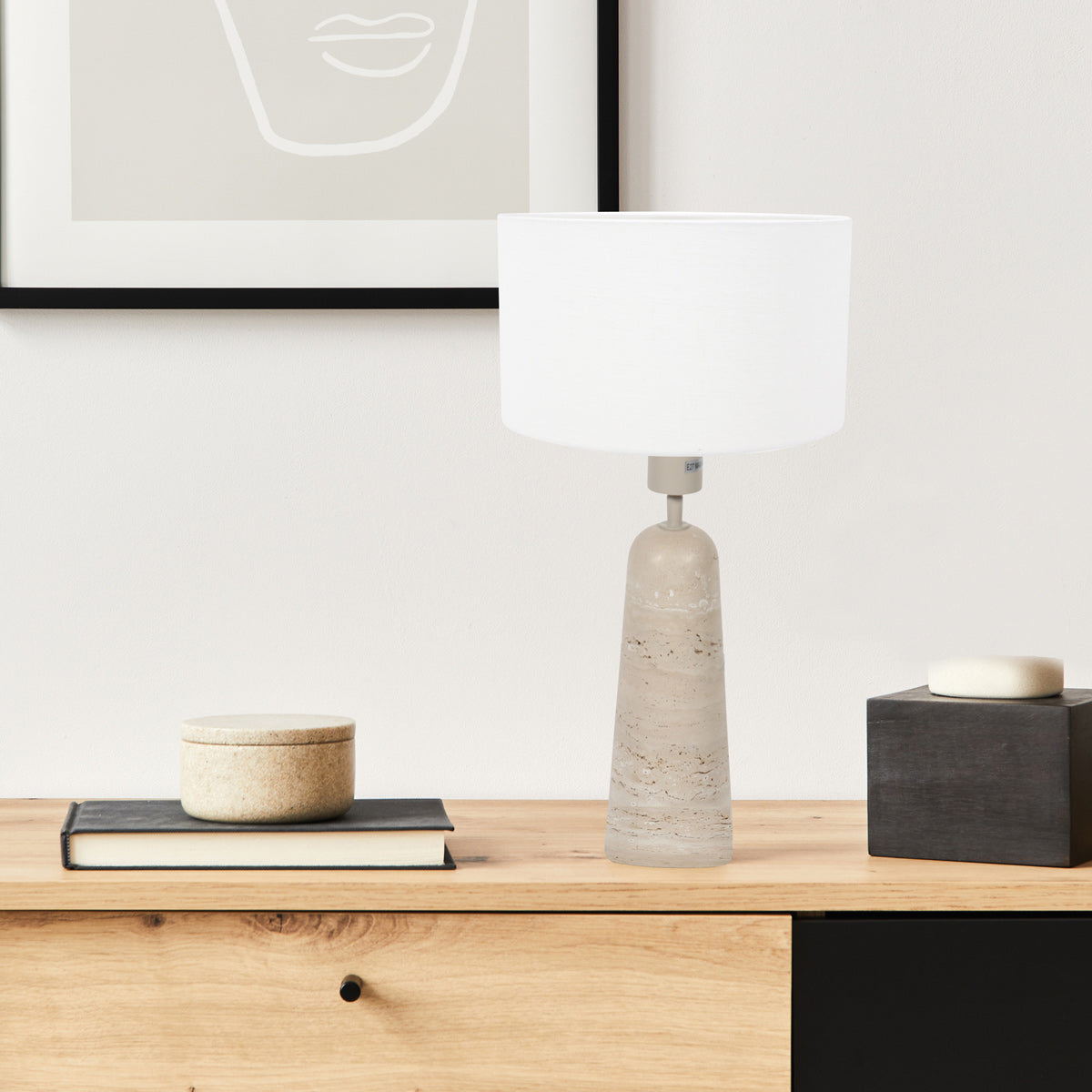 Lampe de chevet travertin Travino posée sur une console dans un salon