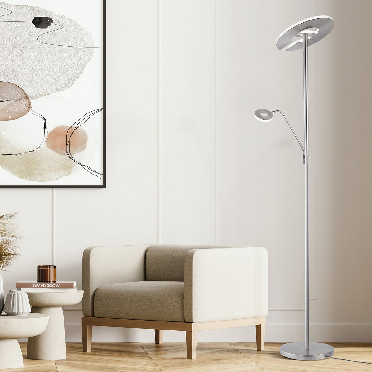 Lampadaire nickel intégré dans un salon contemporain avec fauteuil et tableau.