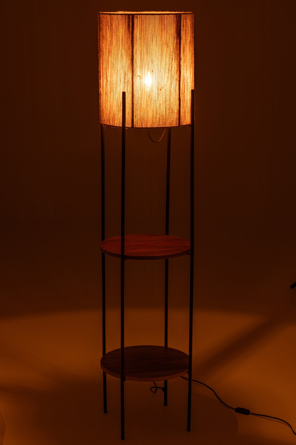 Lampe allumée dans la pénombre, halo chaud diffusé par l'abat-jour