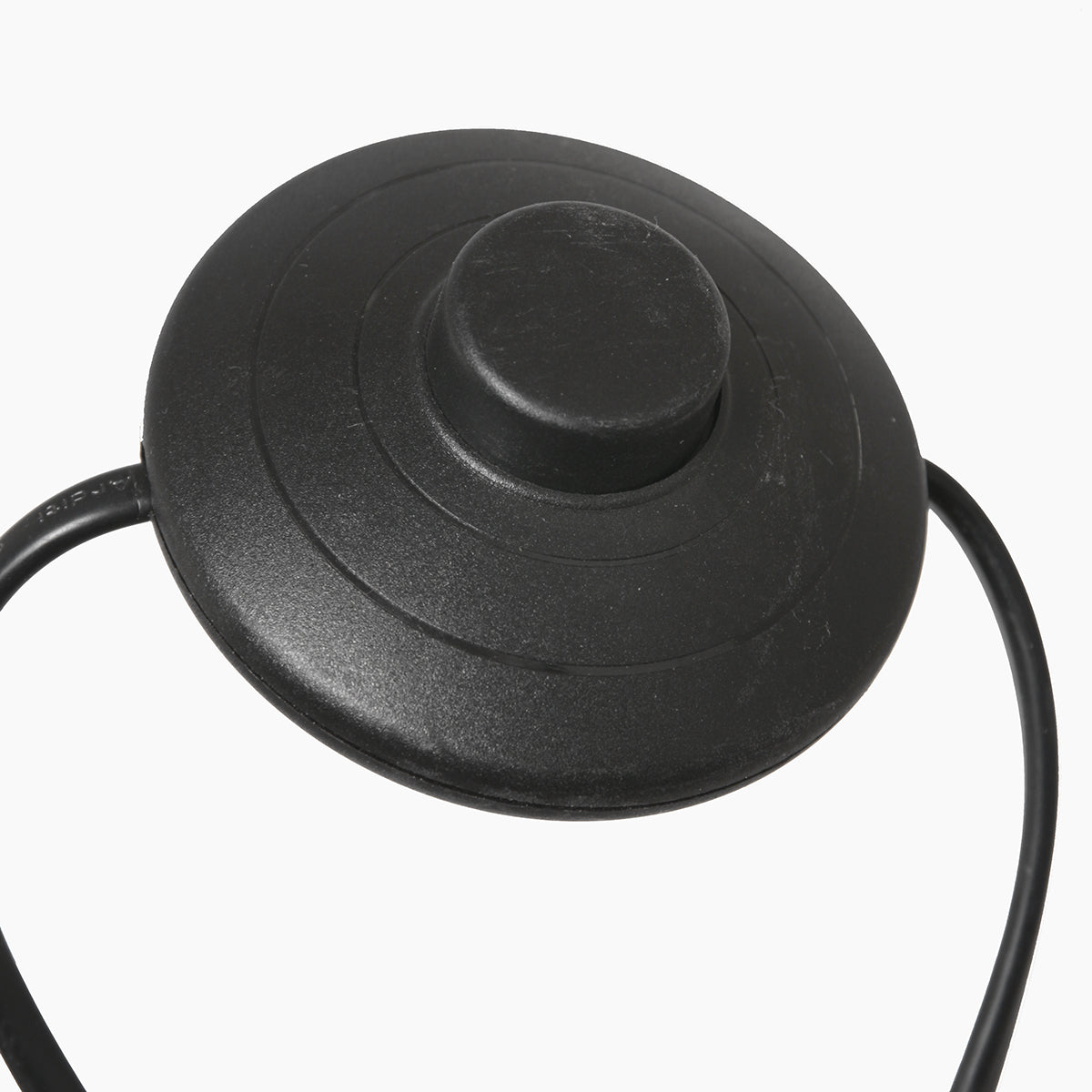 Gros plan sur l'interrupteur pédale noir posé sur le câble électrique