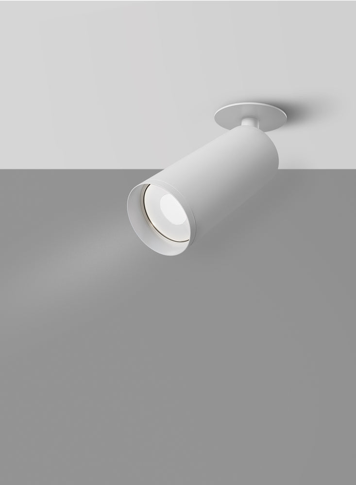 Spot cylindrique blanc orienté vers le mur, faisceau lumineux diffusé dans la pièce