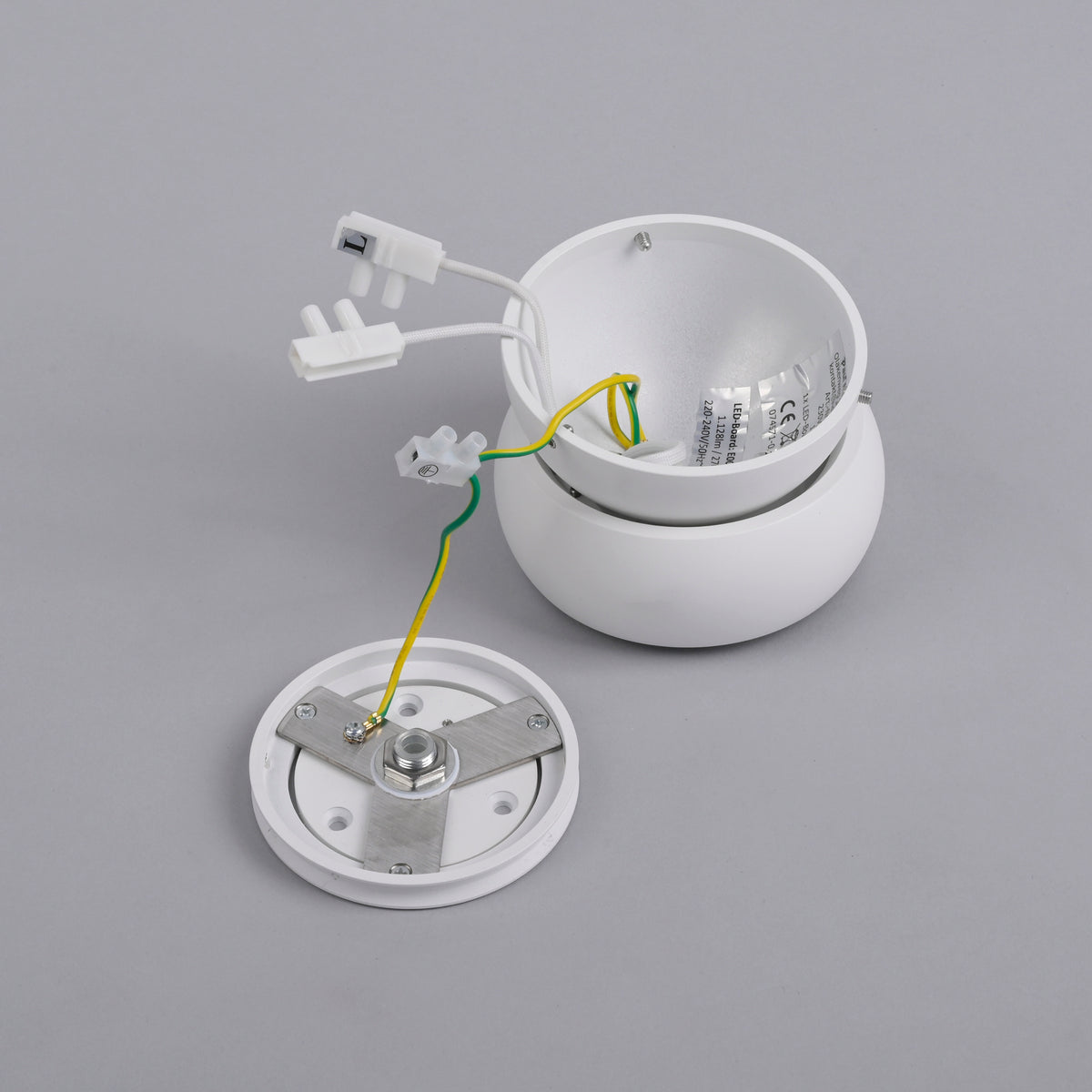 Pièces détachées du plafonnier : platine, connexions électriques et boîtier.