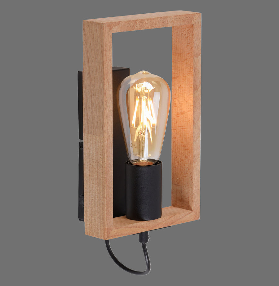 Applique murale en bois clair et métal noir, ampoule à filament allumée, fond gris.
