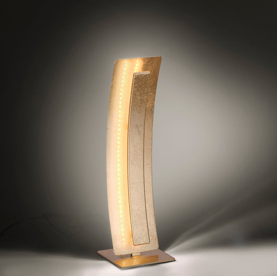 Lampe dorée allumée dans le noir, mettant en valeur la rangée de LED