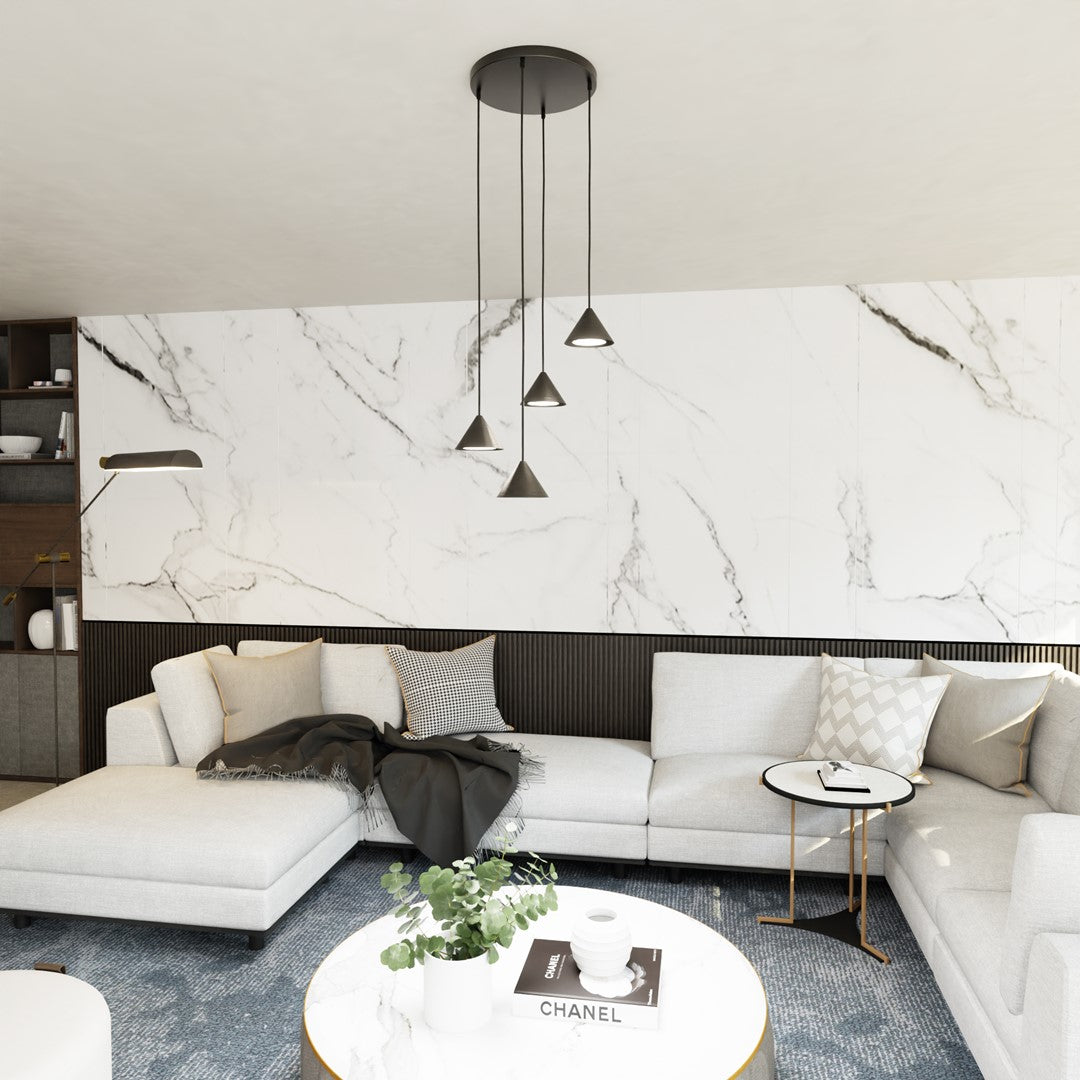 Mise en ambiance salon, suspension noire au-dessus d'un canapé blanc devant un mur en marbre