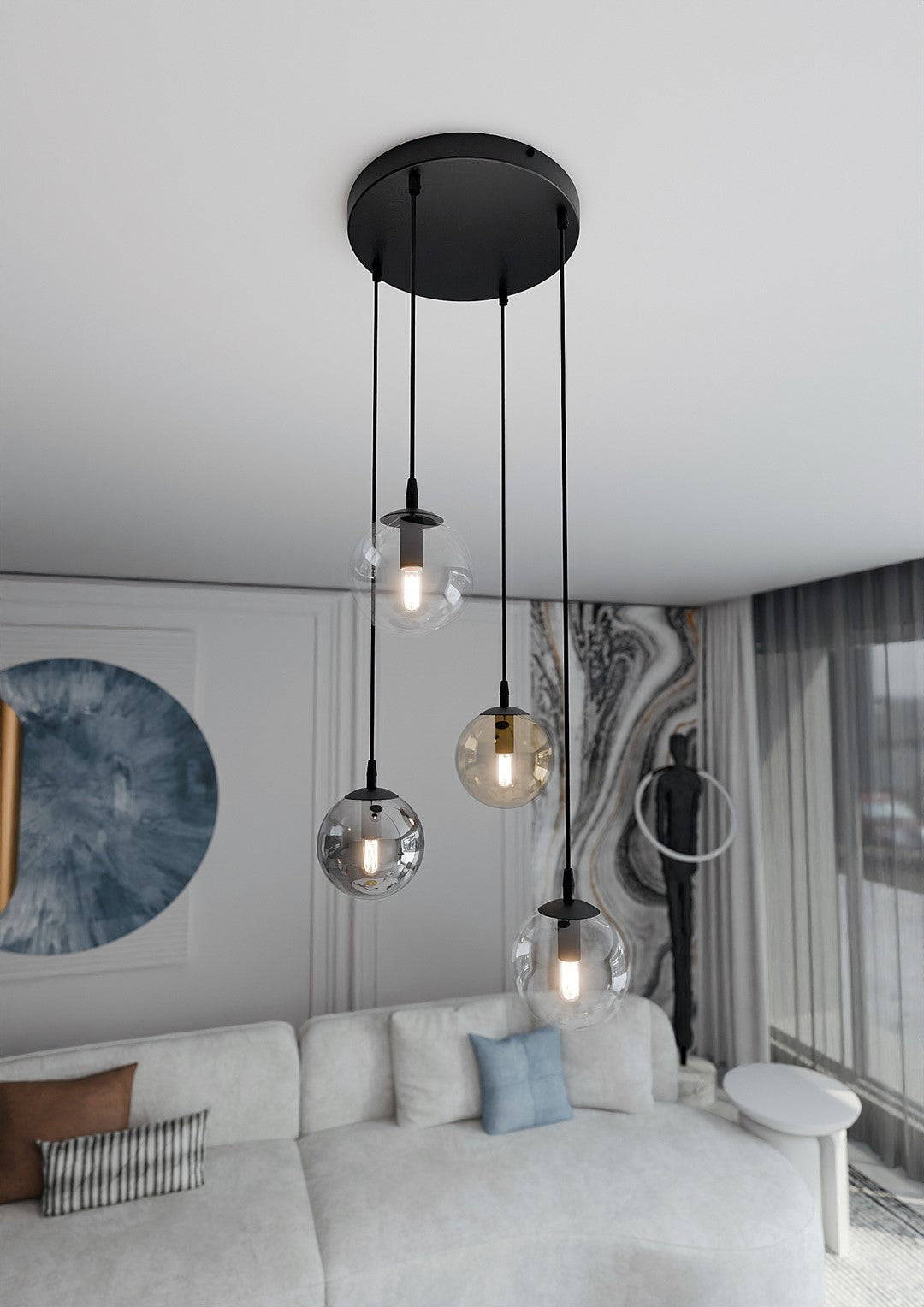 Vue en intérieur du luminaire allumé, globes en verre suspendus devant un mur marbré et canapé.