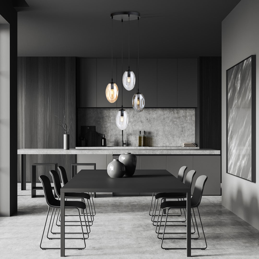 Ambiance cuisine sombre, le luminaire éclairant un plan de travail en béton et une table.