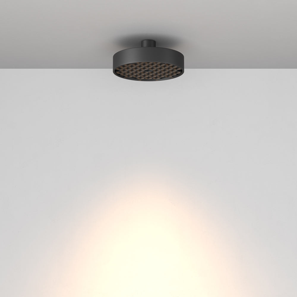 Vue de profil du luminaire fixé au plafond diffusant un halo lumineux.