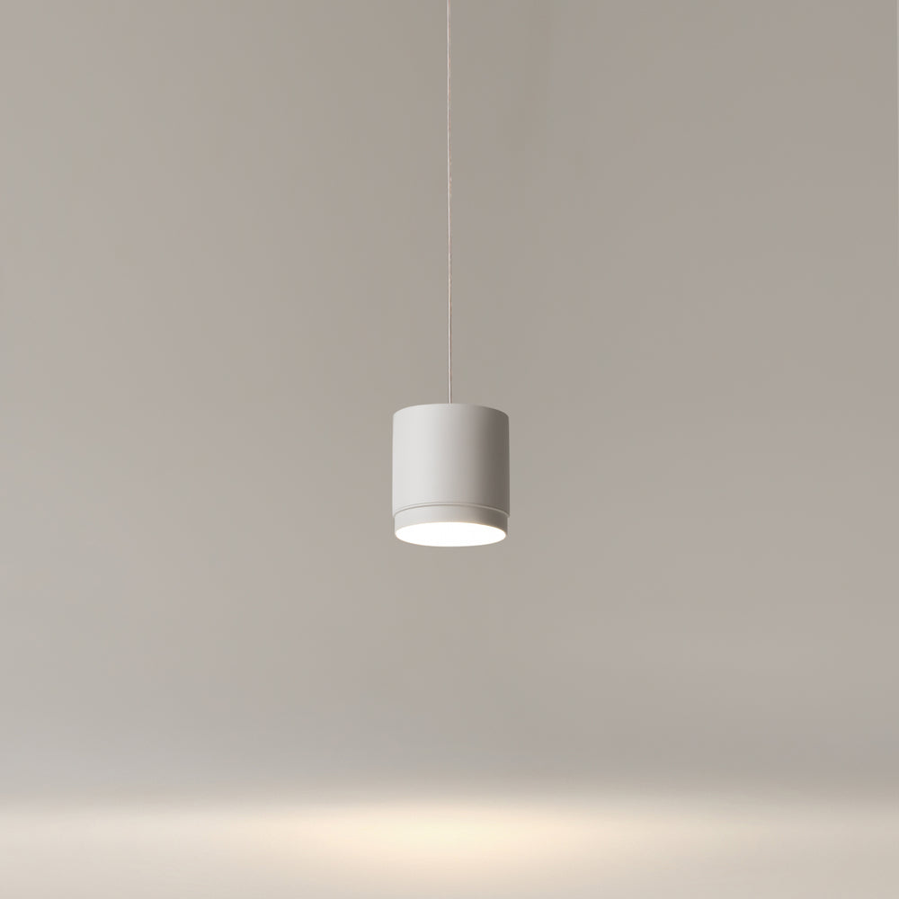le luminaire allumé en ambiance claire, halo chaud vers le bas