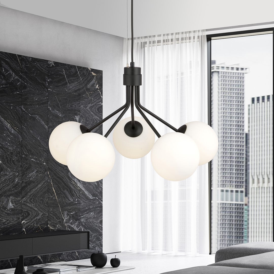 Mise en ambiance dans un salon moderne, suspension noire allumée devant baie vitrée.