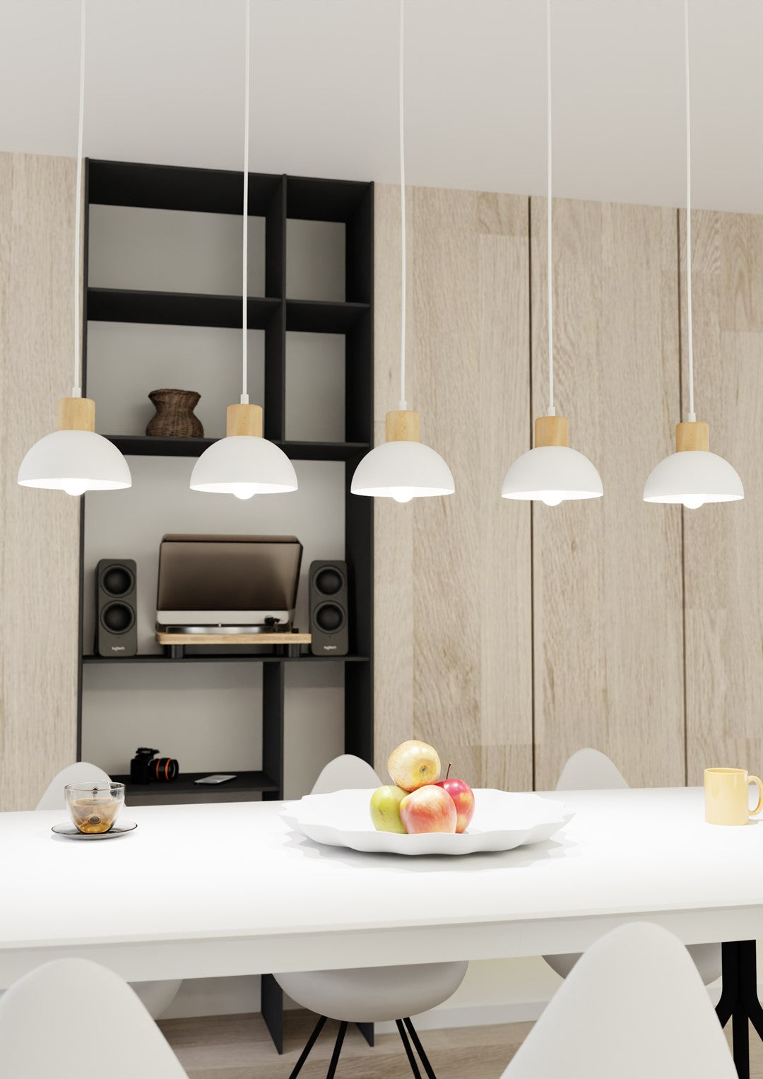Gros plan sur les cinq dômes blancs suspendus, corbeille de pommes sur la table.