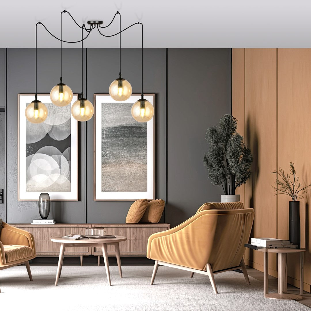 Mise en ambiance salon : suspension allumée au-dessus fauteuils moutarde et table basse
