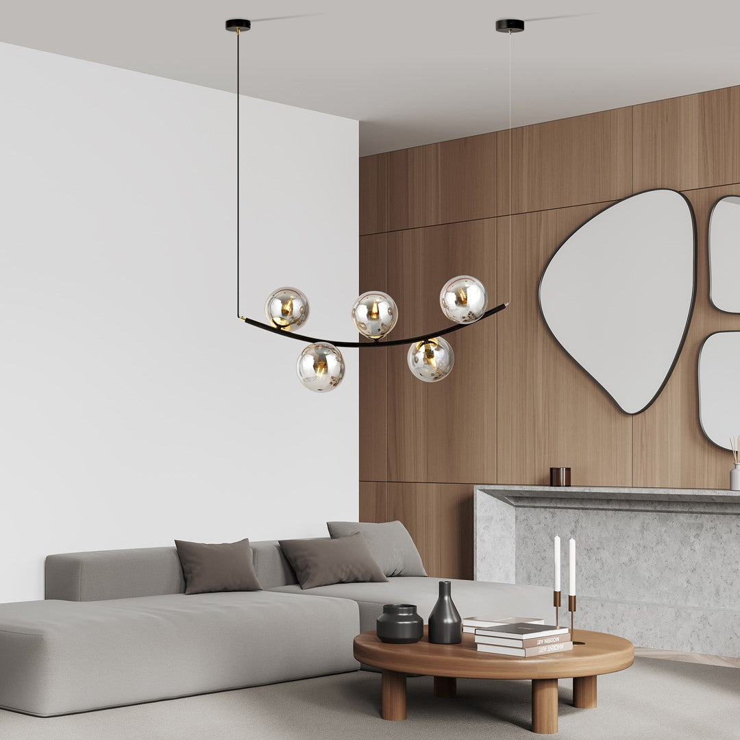 Mise en scène du luminaire suspendu au-dessus d'un salon moderne, canapé et table basse.