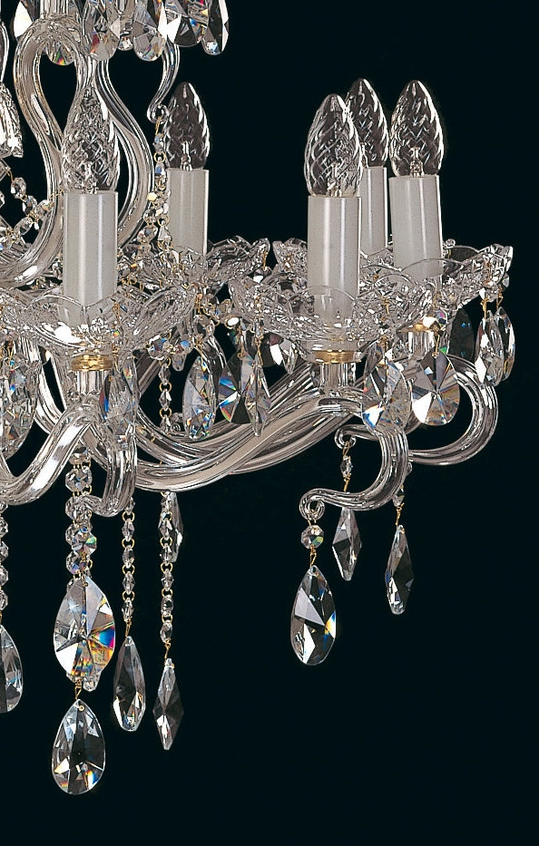 Gros plan sur les bougies et les gouttes de cristal du luminaire.