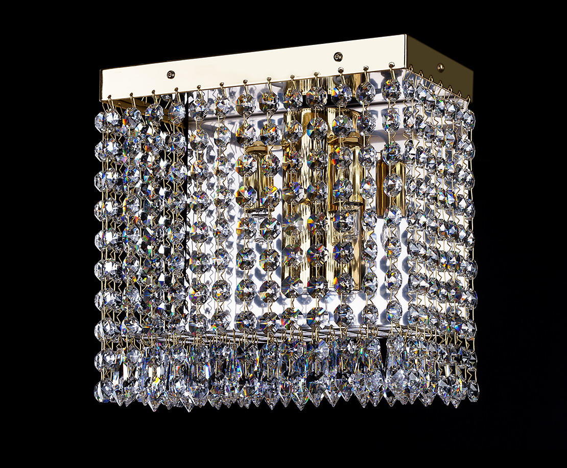 Même applique en cristal avec monture dorée, présentée de face sur fond noir neutre