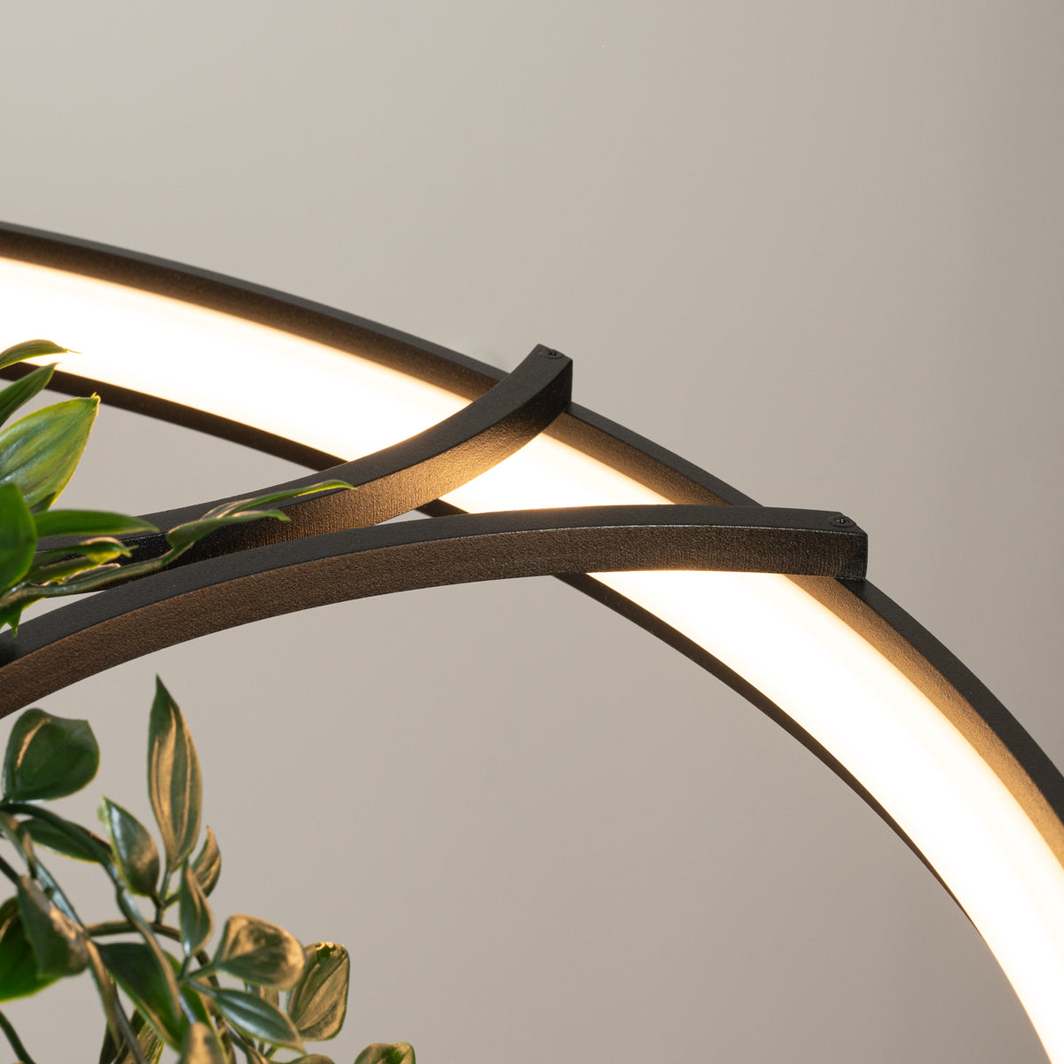 Détail rapproché de la jonction entre les branches noires et le ruban LED allumé