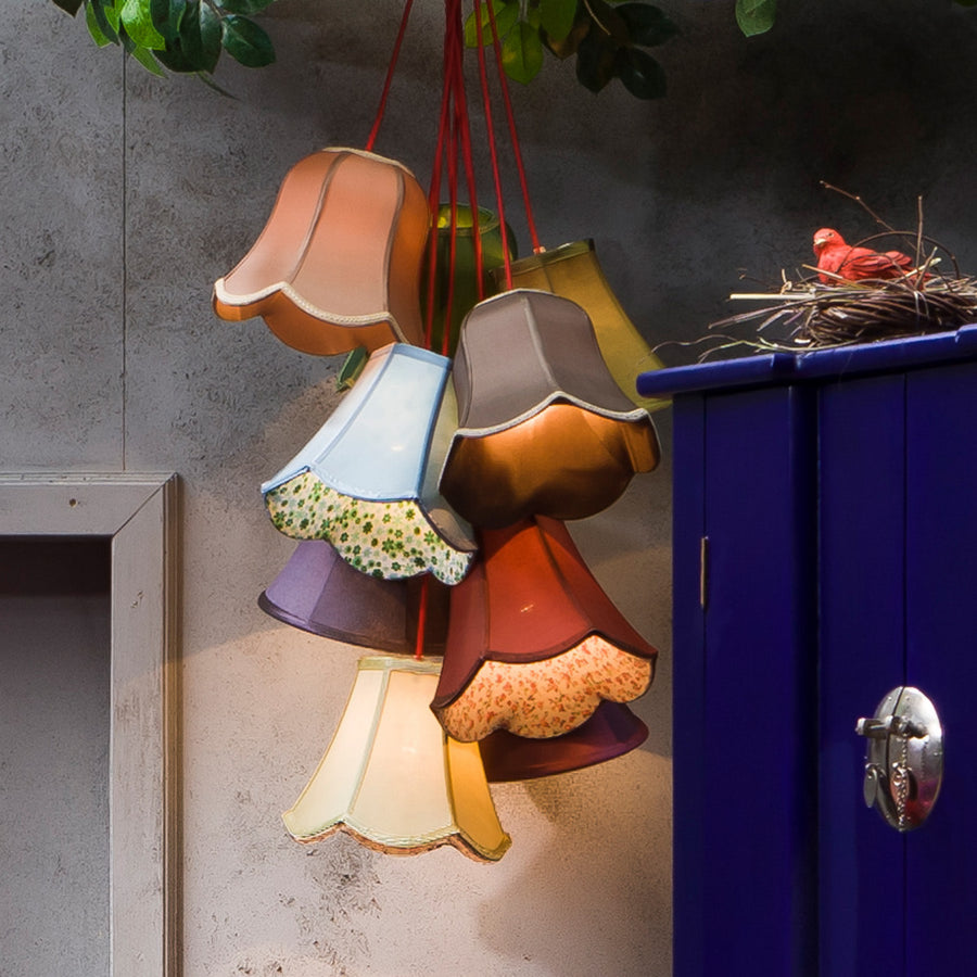 Suspension colorée installée près d’un meuble bleu, avec nid et oiseau décoratifs.