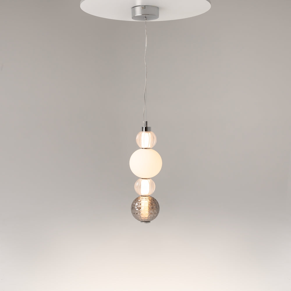 Luminaire suspendu allumé dans une pièce, câble fin et rosace argentée