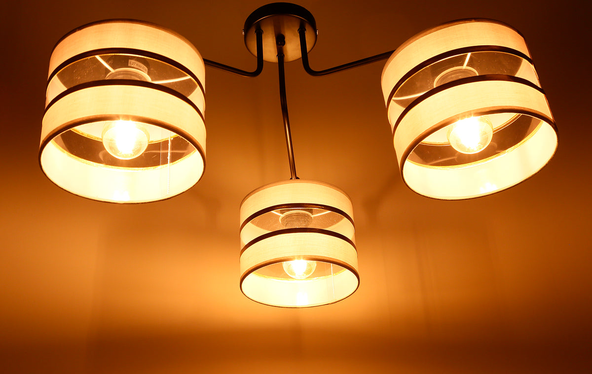 Mise en ambiance du luminaire allumé diffusant une lumière chaude sur le mur orangé